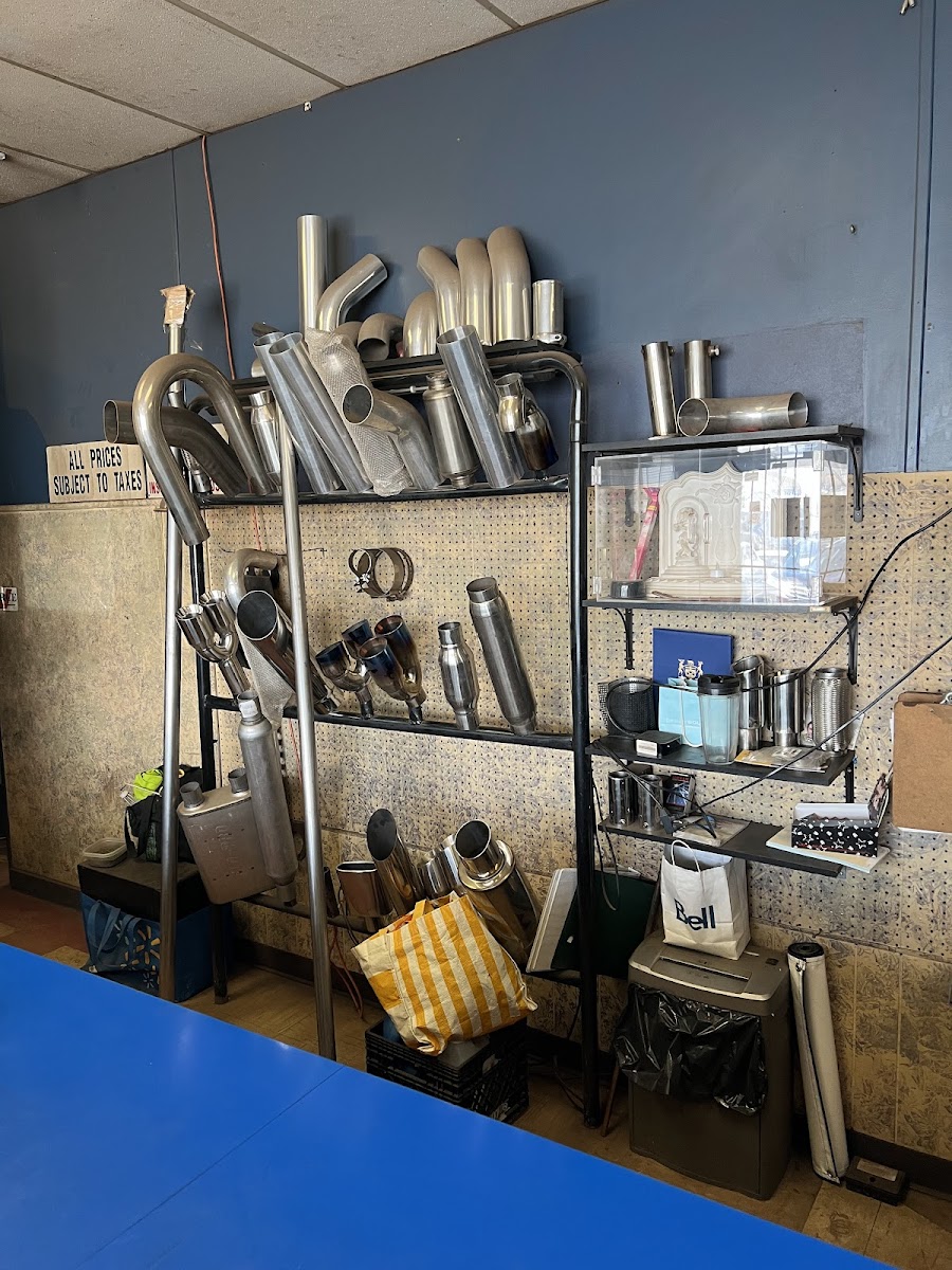 Wall of muffler tips, mandrel-bent pipe, and exhaust components inside the shop