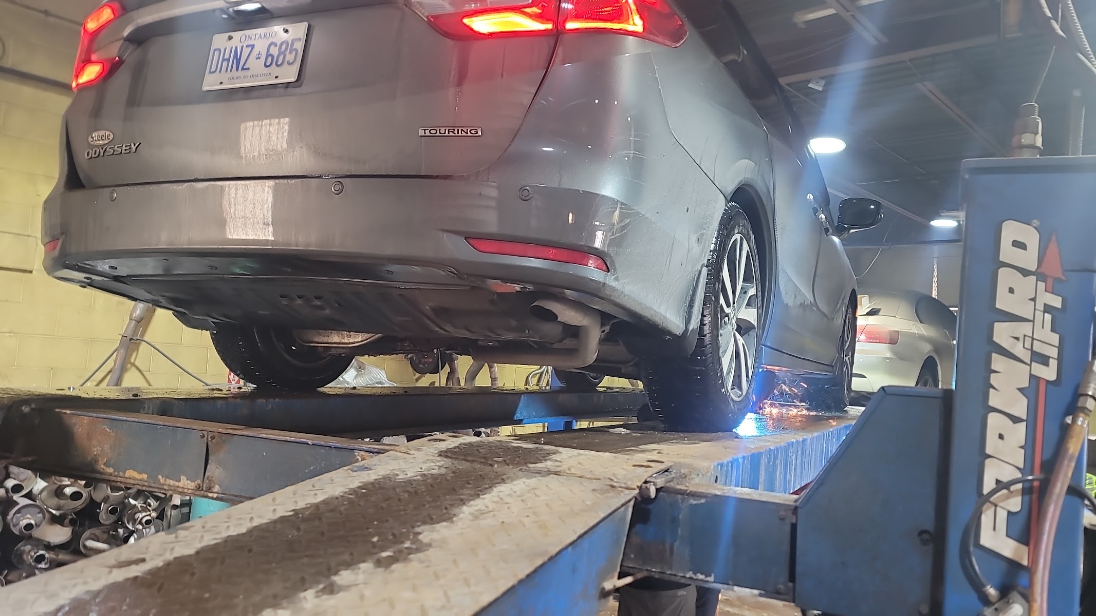 A vehicle on the lift inside the C and D Masters bay, exhaust work in progress