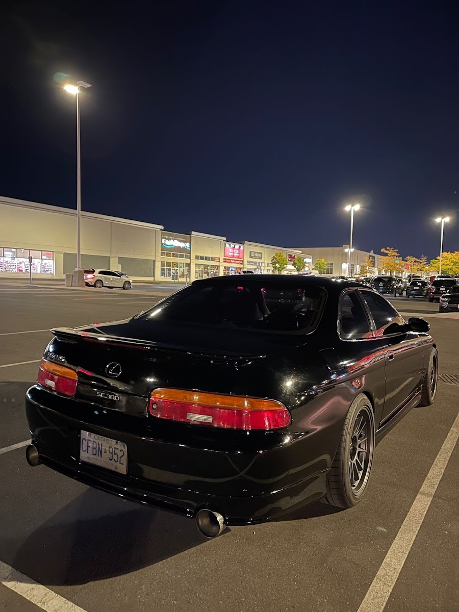 A black Lexus SC300 with custom exhaust parked at C and D Masters at night